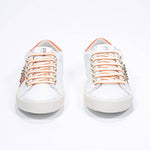 Vista frontale di BASSE bianco e arancione sneaker. Tomaia in pelle con borchie e suola in gomma vintage.