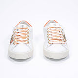 Vista frontale di BASSE bianco e arancione sneaker. Tomaia in pelle con borchie e suola in gomma vintage.
