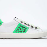 Side profile of low top white and neon green sneaker. Full leather upper with studs and white rubber sole.