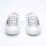 Vorderansicht von Low Top Weiß und Metallic Gold sneaker. Obermaterial aus Vollleder mit Nieten und Vintage-Gummisohle.