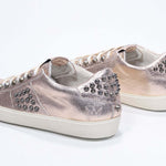 Dreiviertelansicht der Rückseite von Low Top Metallic Rose sneaker. Obermaterial aus Vollleder mit Nieten und Vintage-Gummisohle.