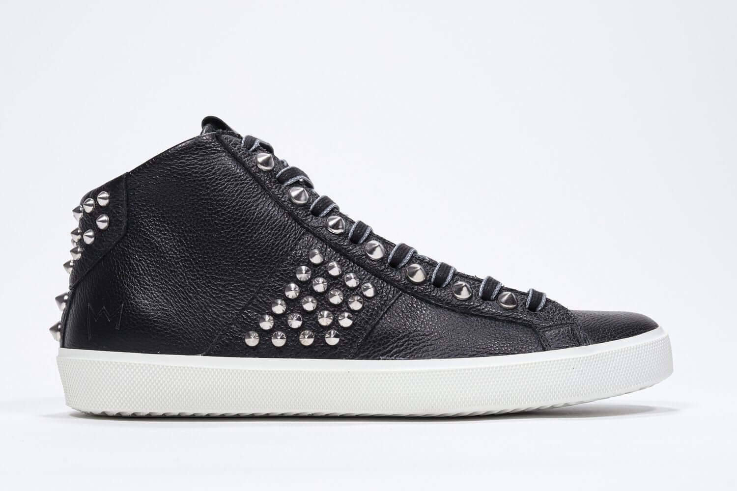 Profilo laterale del mid top nero sneaker. Tomaia in pelle con borchie, zip interna e suola in gomma bianca.