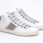 Tre quarti di mid top bianco e rosa metallizzato sneaker. Tomaia in pelle con borchie, zip interna e suola in gomma vintage.