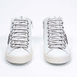 Vista frontale della mid top bianca e rosa metallizzata sneaker. Tomaia in pelle con borchie, zip interna e suola in gomma vintage.