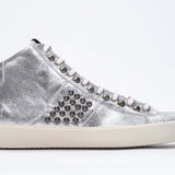Seitenprofil von Mid-Top Metallic-Silber sneaker. Obermaterial aus Vollleder mit Nieten, einem internen Reißverschluss und einer Vintage-Gummisohle.