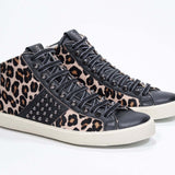 Tre quarti di un mid top leopardato sneaker. Tomaia in vitello e pelle con borchie, zip interna e suola in gomma vintage.
