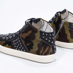 Three quarter back view of mid top camouflage print sneaker. Haircalf and leather upper with studs, an internal zip and vintage rubber sole.