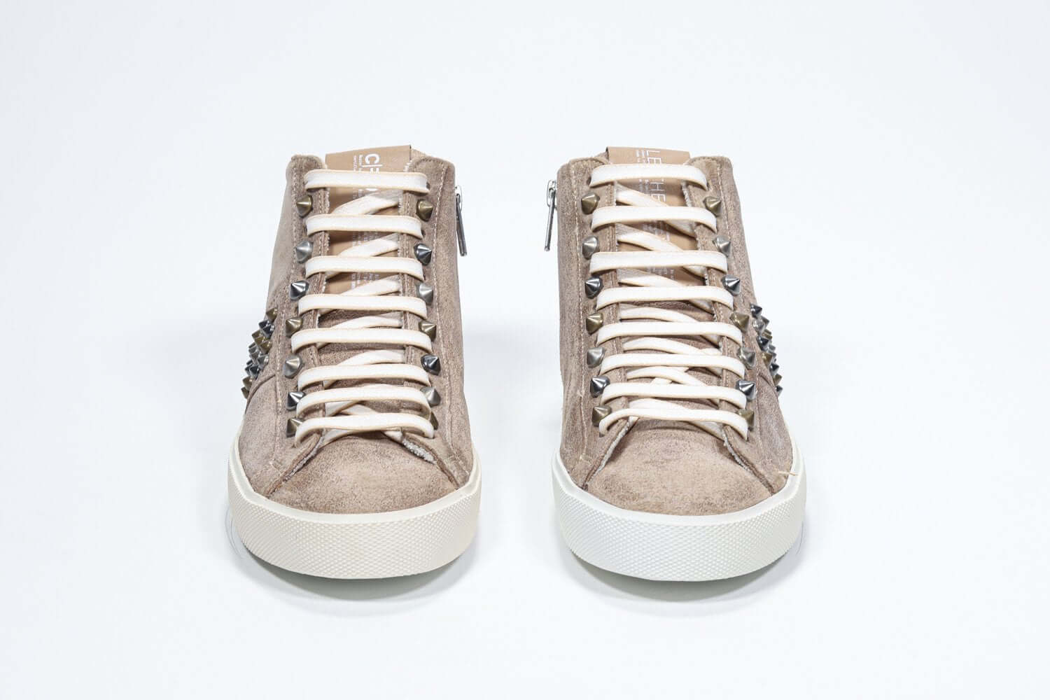Vista frontale della mid top color cuoio sneaker. Tomaia in pelle scamosciata con borchie, zip interna e suola in gomma vintage.