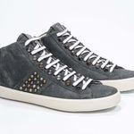 Three quarter front view of mid top khaki sneaker. Full suede upper with studs, an internal zip and vintage rubber sole.