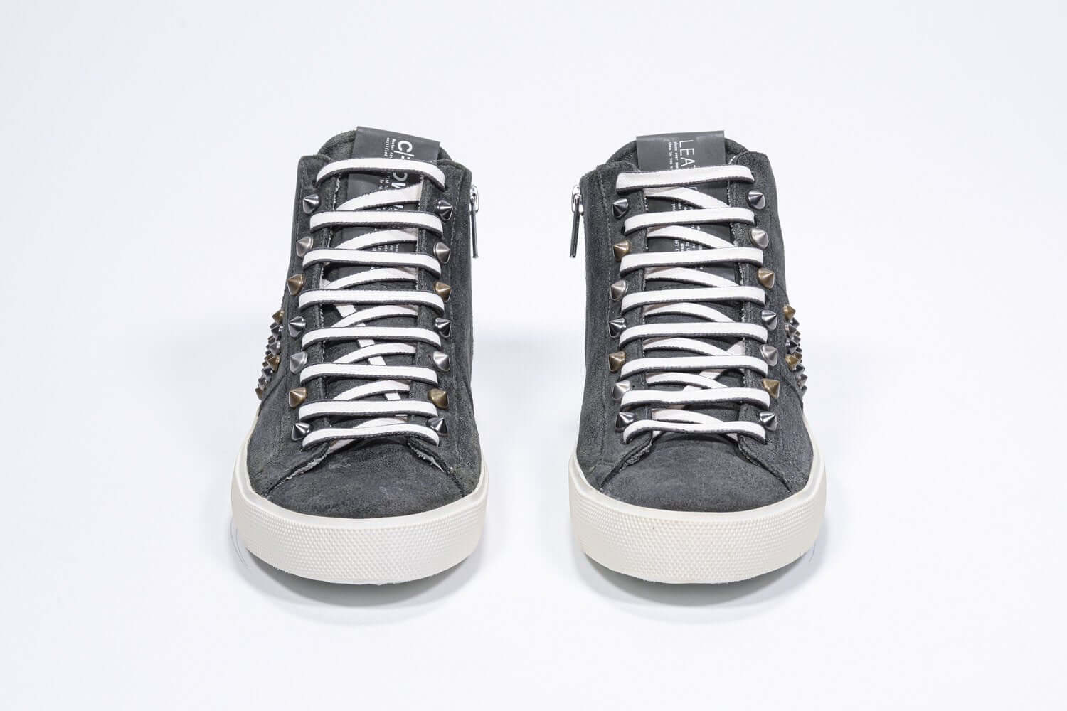 Front view of mid top khaki sneaker. Full suede upper with studs, an internal zip and vintage rubber sole.