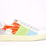 Side profile of low top sneaker. Patchwork upper of mixed materials and silver studs.