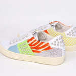 Three quarter back view of low top sneaker. Patchwork upper of mixed materials and silver studs.