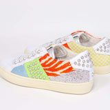 Three quarter back view of low top sneaker. Patchwork upper of mixed materials and silver studs.