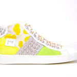 Profil latéral du top moyen sneaker. Tige en patchwork de matières mixtes et clous argentés.