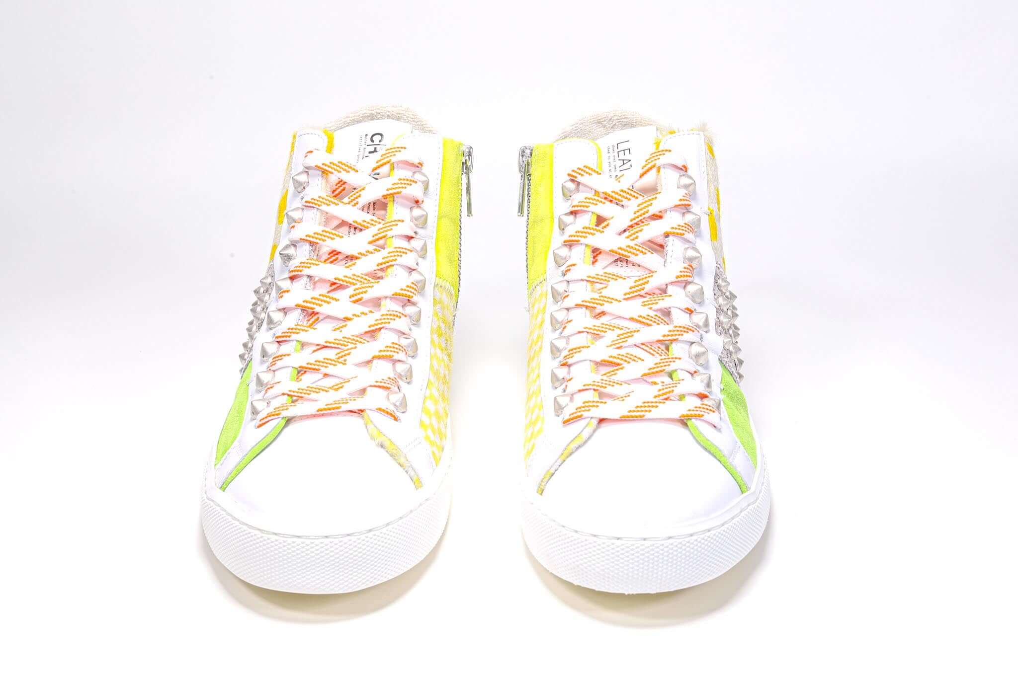 Vue de face du modèle mid top sneaker. Tige en patchwork de matières mixtes et clous argentés.
