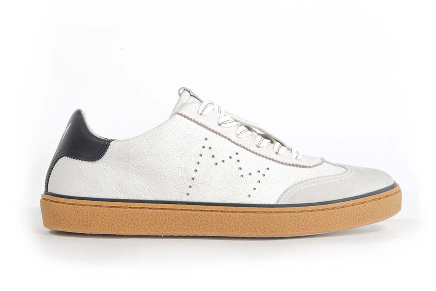 Side profile view of low top retro sneaker in white and grey with navy detailing and perforated crown logo on upper. Full leather upper and honey colored recycled rubber sole.