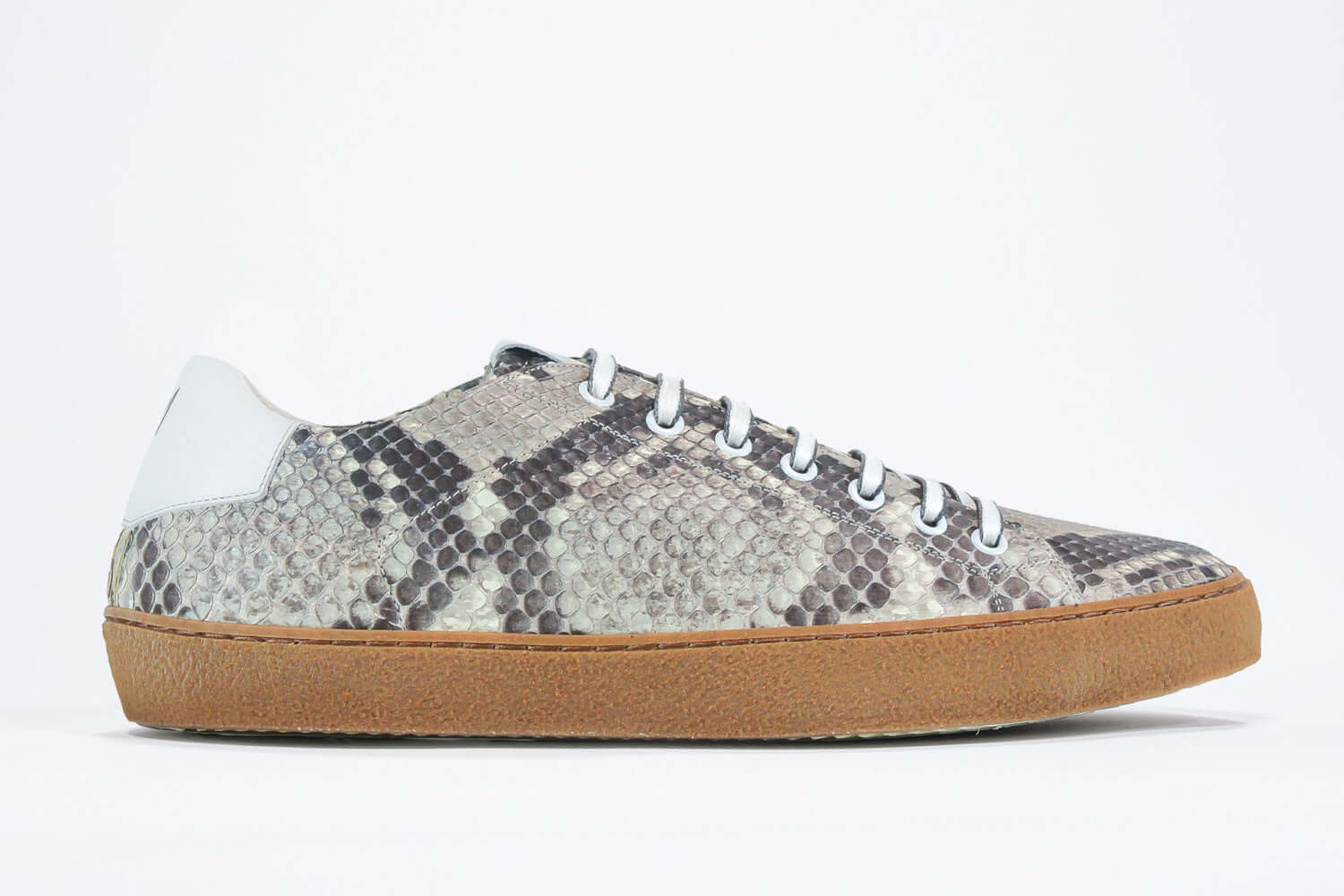 Side profile of low top python skin sneaker. Full snake skin upper and honey coloured rubber sole.