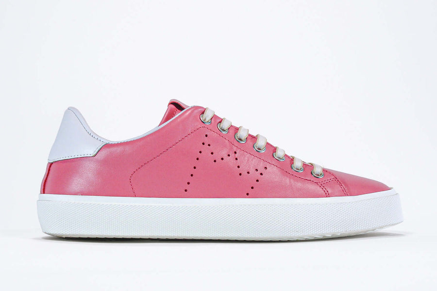 Side profile view of low top pink sneaker with white detailing and perforated crown logo on upper. Full leather upper and white rubber sole.
