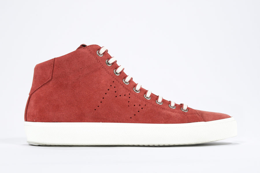  Side profile of mid top sneaker in red suede and leather upper, internal zip and white sole.