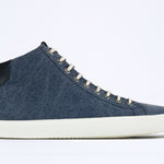  Side profile of mid top sneaker in denim blue canvas and leather upper, internal zip and white sole.