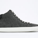 Side profile of mid top sneaker in black canvas and leather upper, internal zip and white sole.