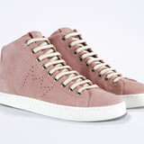 Three quarter front view of mid top sneaker in pink suede and leather upper, internal zip and white sole.