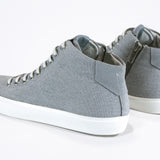 Vue de trois quarts arrière de la chaussure de sport sneaker avec une tige en toile grise, une fermeture éclair interne et une semelle blanche.