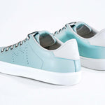 Three quarter back view of low top sky blue sneaker with white detailing and perforated crown logo on upper. Full leather upper and white rubber sole.