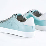 Three quarter back view of low top sky blue sneaker with white detailing and perforated crown logo on upper. Full leather upper and white rubber sole.