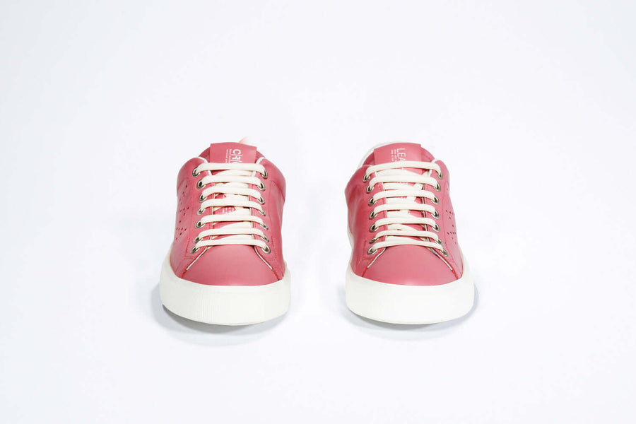 Front view of low top pink sneaker with white detailing and perforated crown logo on upper. Full leather upper and white rubber sole.
