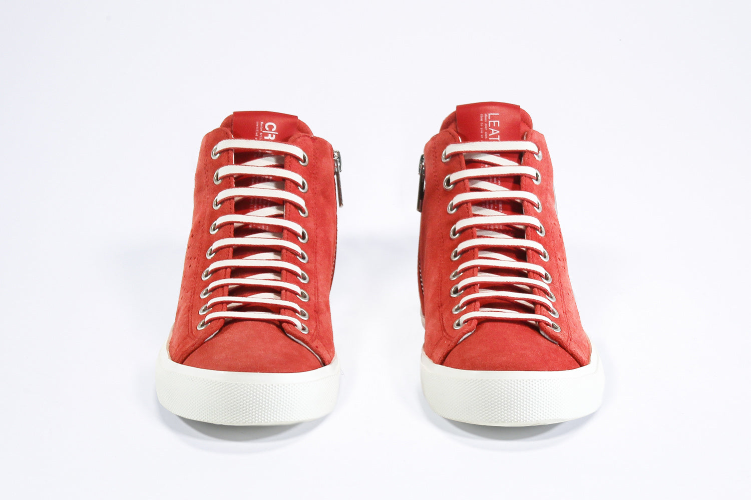 Vue de face de la chaussure de sport sneaker en daim rouge et cuir, avec fermeture éclair interne et semelle blanche.