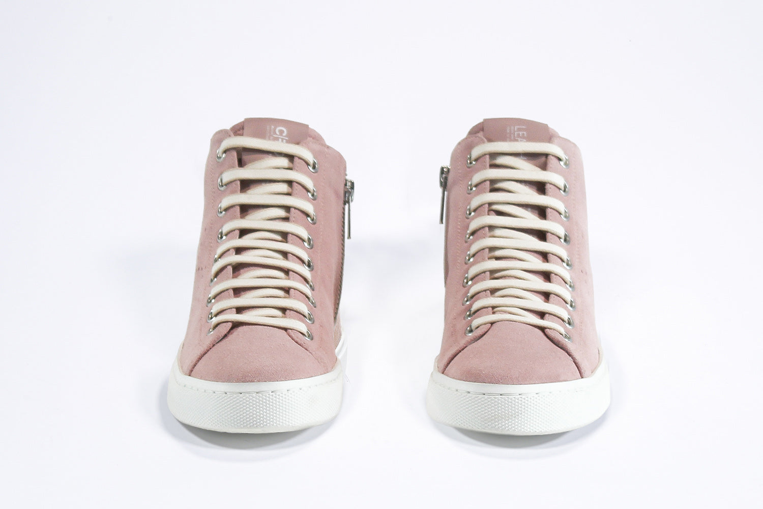Vue de face de la chaussure de sport sneaker en cuir et daim rose, avec fermeture éclair interne et semelle blanche.