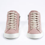 Front view of mid top sneaker in pink suede and leather upper, internal zip and white sole.