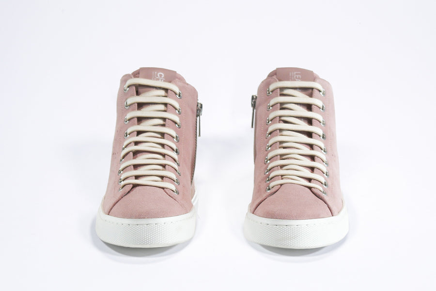 Front view of mid top sneaker in pink suede and leather upper, internal zip and white sole.