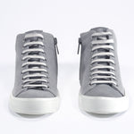 Vorderansicht von sneaker mit durchgehendem grauem Canvas-Obermaterial, innerem Reißverschluss und weißer Sohle.