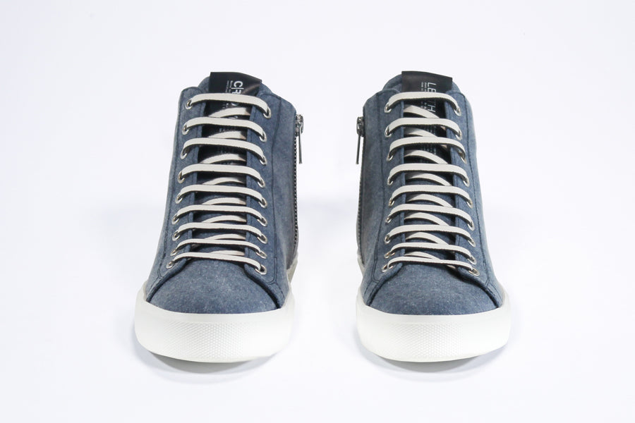 Front view of mid top sneaker in denim blue canvas and leather upper, internal zip and white sole.