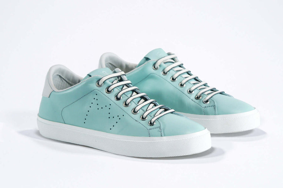 Three quarter front view of low top sky blue sneaker with white detailing and perforated crown logo on upper. Full leather upper and white rubber sole.