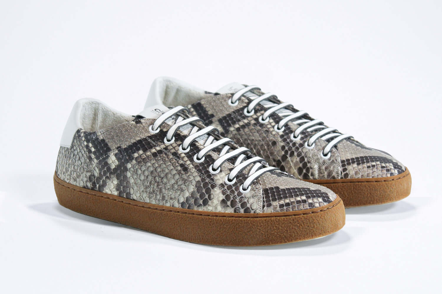 Three quarter front view of low top python skin sneaker. Full snake skin upper and honey coloured rubber sole.