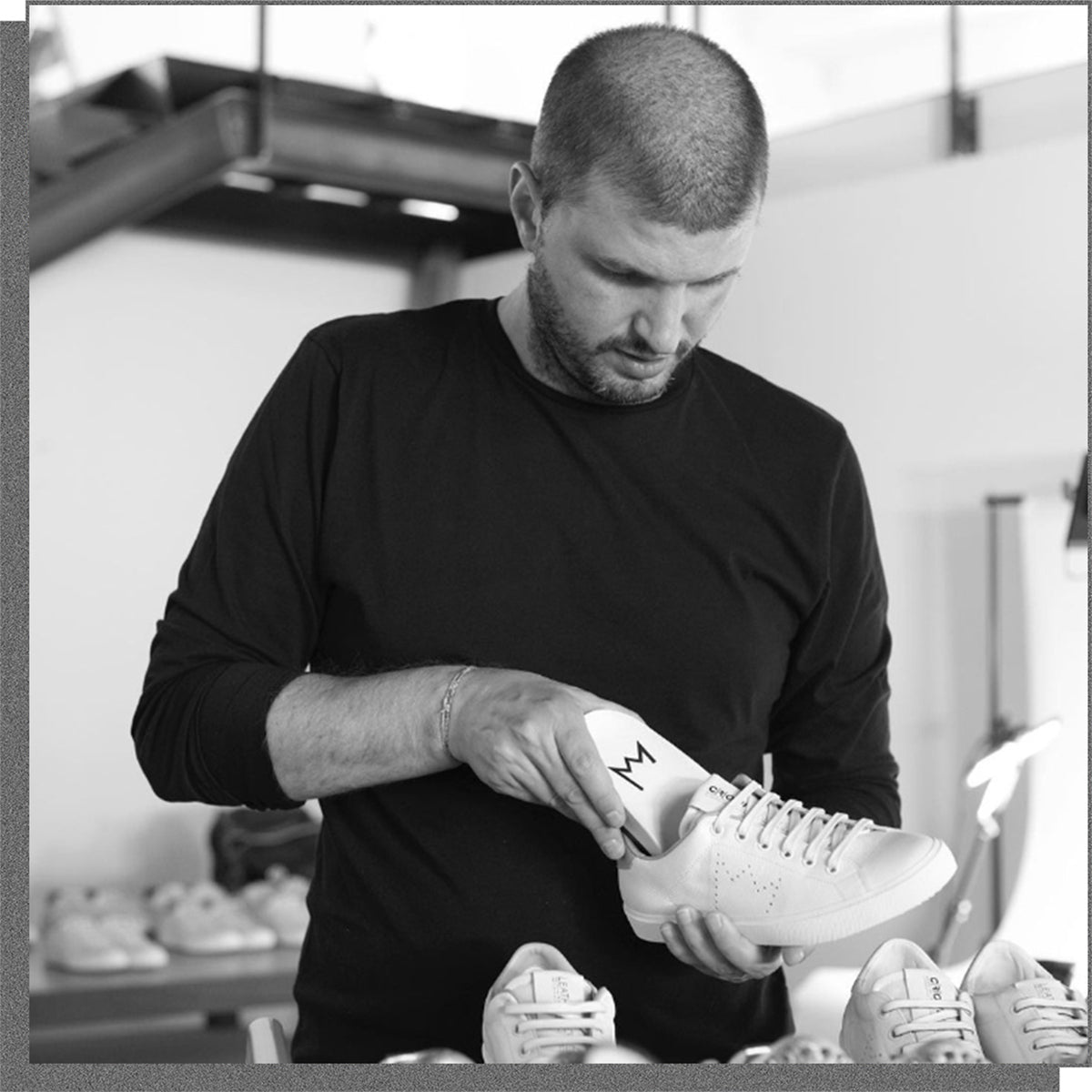 Kunsthandwerker beim Einlegen der Einlegesohle in Leather C|R|OWN sneakers .