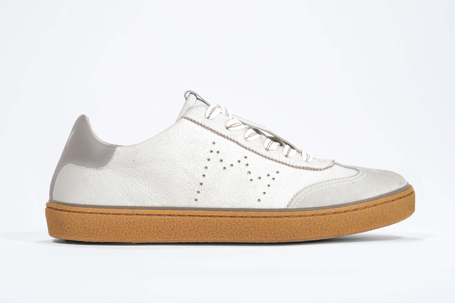 Side view of low top retro sneaker in distressed white leather with fawn detailing and honey coloured recycled rubber sole.