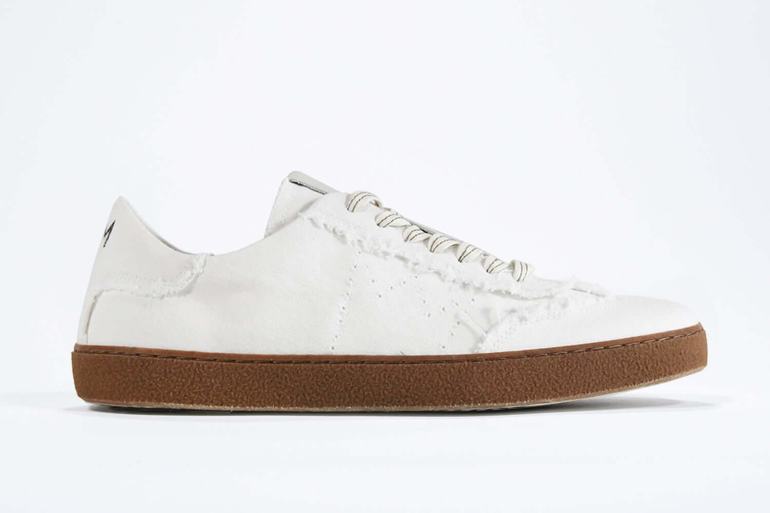 Side view of low top retro sneaker in distressed white canvas, with honey coloured recycled rubber sole.