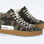Three quarter front view of high top canvas sneaker. Camouflage canvas upper with signature red stitching and a dark natural rubber sole.
