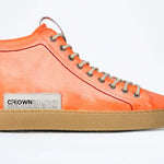 Side profile of high top canvas sneaker. Canvas upper hand painted in gradated fluo orange paint. Pale natural rubber sole.