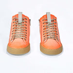 Front view of high top canvas sneaker. Canvas upper hand painted in gradated fluo orange paint. Pale natural rubber sole.