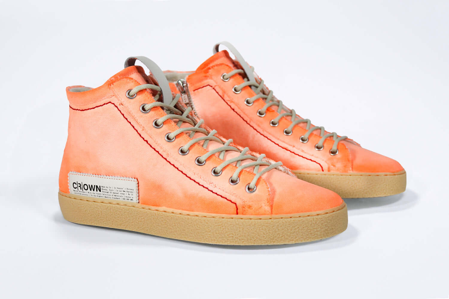 Three quarter front view of high top canvas sneaker. Canvas upper hand painted in gradated fluo orange paint. Pale natural rubber sole.
