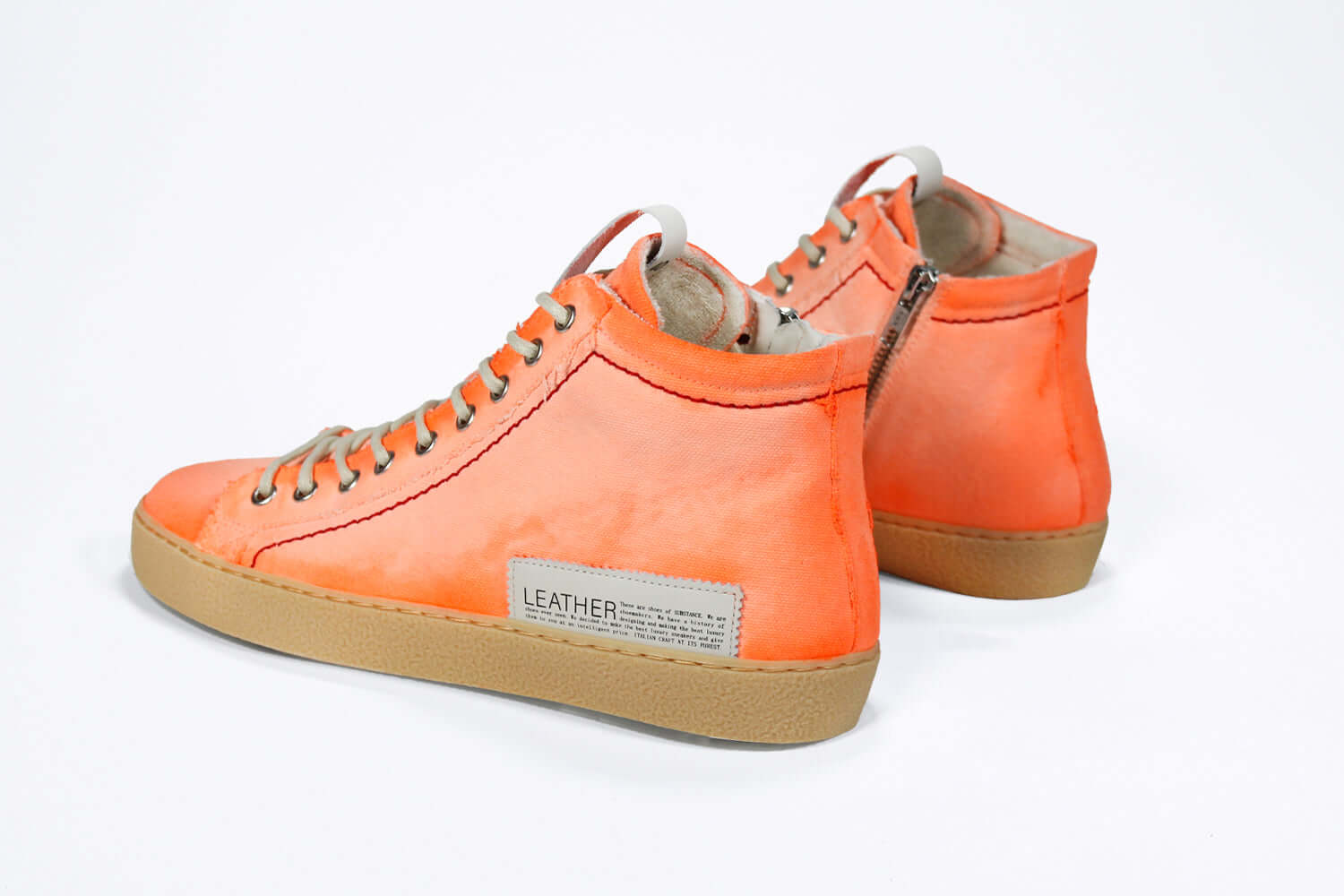 Back view of high top canvas sneaker. Canvas upper hand painted in gradated fluo orange paint. Pale natural rubber sole.