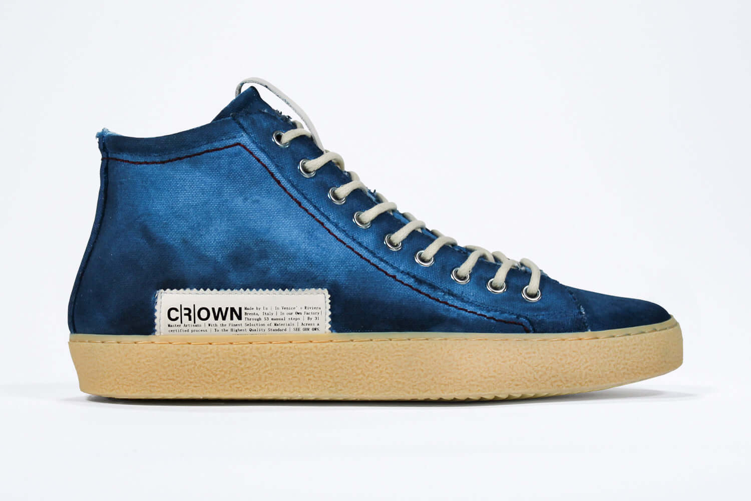 Side profile of high top canvas sneaker. Canvas upper hand painted in gradated blue paint. Pale natural rubber sole.