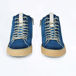 Front view of high top canvas sneaker. Canvas upper hand painted in gradated blue paint. Pale natural rubber sole.