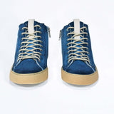Front view of high top canvas sneaker. Canvas upper hand painted in gradated blue paint. Pale natural rubber sole.