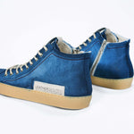 Back view of high top canvas sneaker. Canvas upper hand painted in gradated blue paint. Pale natural rubber sole.